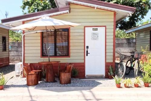 ein kleines Haus mit einem Tisch und einem Sonnenschirm in der Unterkunft Homey Inn- Olango Island Staycation in Lapu Lapu City