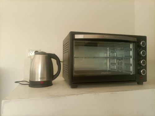 a microwave oven sitting on a counter next to a coffee pot at Alka hermoso y cómodo departamento in Morón