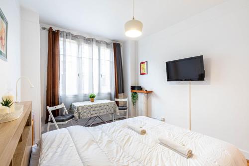 ein Schlafzimmer mit einem Bett und einem TV an der Wand in der Unterkunft GuestReady - Contemporary comfort near Paris in Clichy