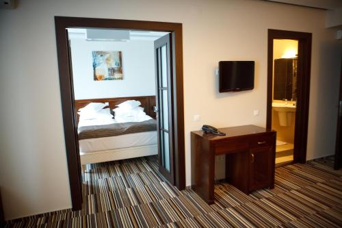 a hotel room with a bed and a mirror at Hotel Belvedere in Botoşani