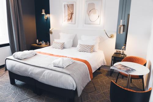 昂熱的住宿－Hôtel D'Anjou，酒店客房设有两张床和一张桌子。