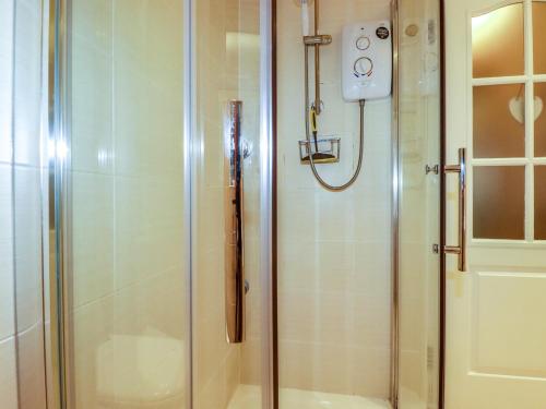 a shower in a bathroom with a glass door at Summerfield Cottage in Gorran Haven