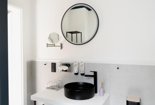 einen Spiegel an einer Wand über einem Waschbecken im Bad in der Unterkunft KRACHER Ferienhaus Landhaus No 1 in Illmitz