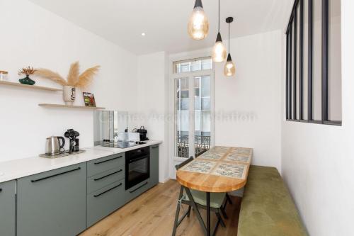 une cuisine avec une table au milieu dans l'établissement August, à Cannes