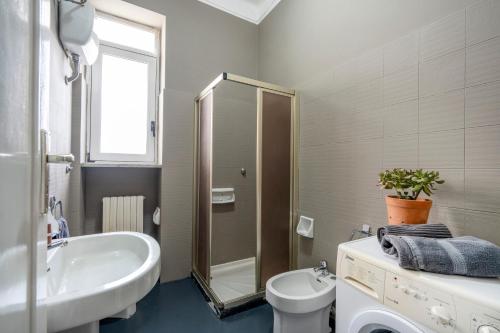 y baño con lavabo, aseo y ducha. en Casa Bonaive, ampio trilocale vista mare, en Bari