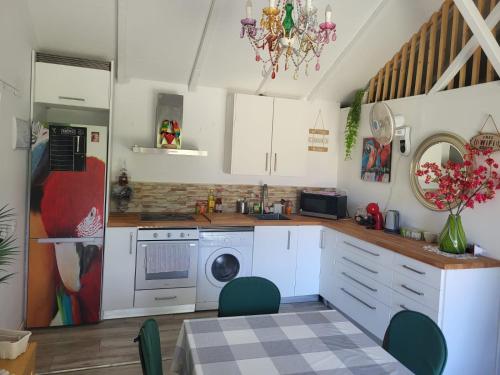uma cozinha com armários brancos e uma máquina de lavar roupa em Tiny House Teresa em Pontons