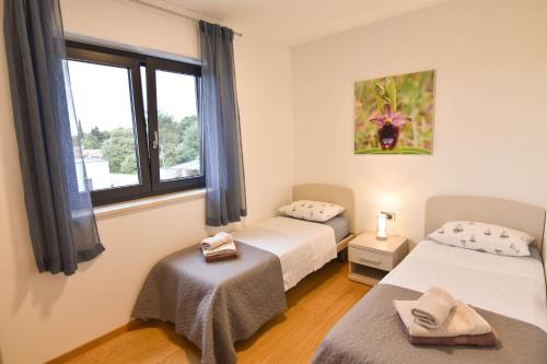pokój z dwoma łóżkami i oknem w obiekcie Luxury apartment Grotta with sea view and swimming pool w mieście Premantura