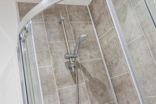 a shower with a shower head in a bathroom at Modern apartment -City Centre Location By Luxiety Stays Serviced Accommodation Southend on Sea in Southend-on-Sea