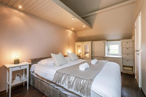 - une chambre avec un grand lit et des draps blancs dans l'établissement Charming apartment "De Watersnip" in De Haan, au Coq