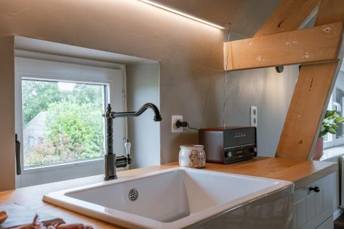 une cuisine avec un évier et une fenêtre dans l'établissement Charming apartment "De Watersnip" in De Haan, au Coq