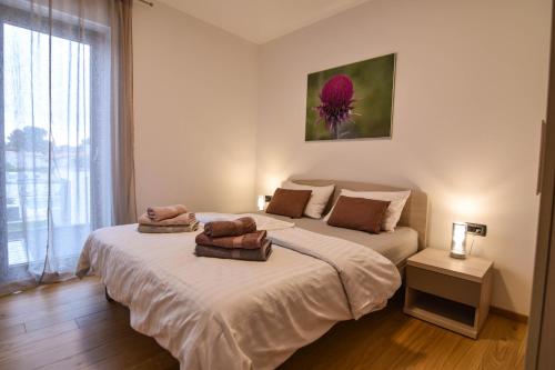 a bedroom with two beds with towels on them at Luxury apartment Porto with sea view and swimming pool in Premantura