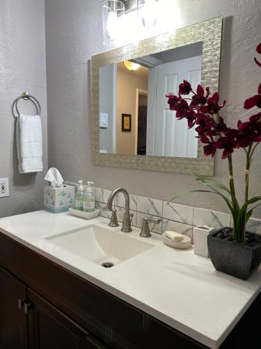a bathroom sink with a vase of flowers on it at Emerald City 3 Bedroom 1 bath Home in Eugene