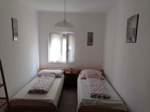 twee bedden in een kleine kamer met een raam bij Apartments in Balatonmariafürdo 19567 in Balatonmáriafürdő