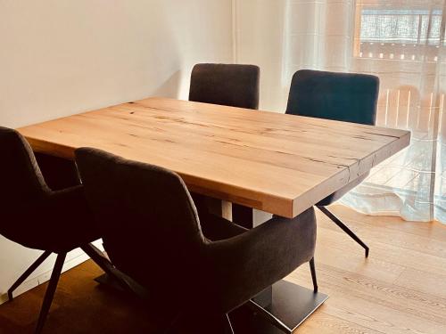 a wooden table with four chairs around it at Apartment im Stenna Vallada direkt bei den Bergbahnen in Flims