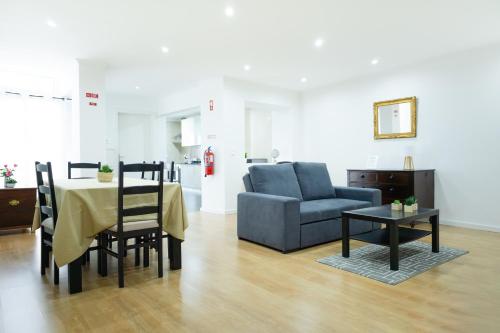 a living room with a table and a couch and a chair at Avenida House 1 in Ponta Delgada