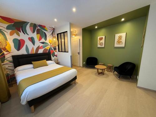 una camera con letto, tavolo e sedie di Hôtel Le Blason a Amboise