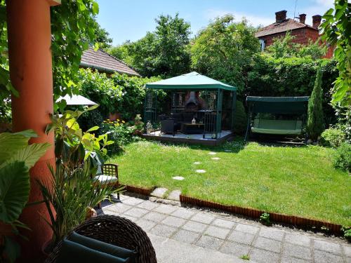 a garden with a gazebo in the grass at Villa-Hotel Escala in Cluj-Napoca