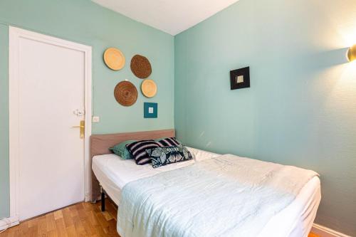 une chambre avec un lit dans une pièce aux murs bleus dans l'établissement GuestReady - Bel Apt à deux pas des Champs-Elysées, à Paris