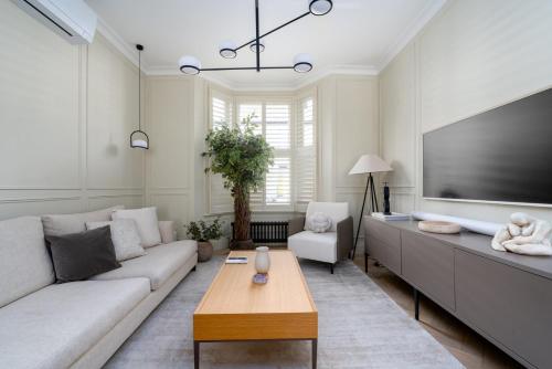 a living room with a large flat screen tv at GuestReady - Luxurious home in Archway in London