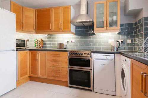 a kitchen with a stove and a dishwasher at GuestReady - Cityscape Retreat near The Shard in London