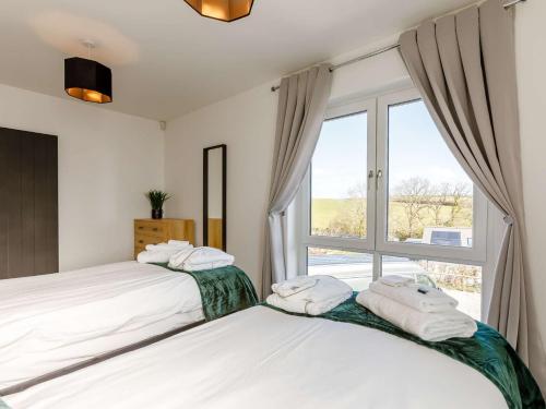 2 camas en un dormitorio con ventana en 4 Bed in Bude 85673 en Bridgerule