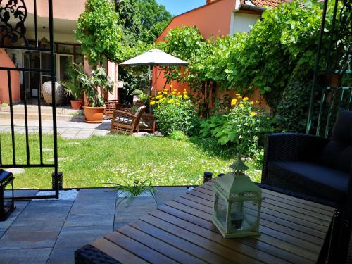 a patio with a table and an umbrella in a yard at Villa-Hotel Escala in Cluj-Napoca