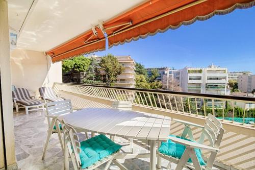un patio avec une table et des chaises sur un balcon dans l'établissement The Fifth Sky – Terrace & Parking Near Sea, à Cannes