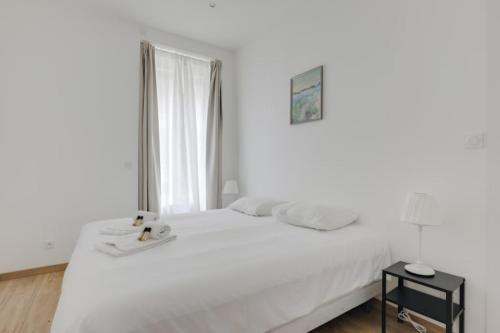 une chambre blanche avec un lit blanc et une fenêtre dans l'établissement GuestReady - 1-BR, 5 minutes from train station, à Lyon