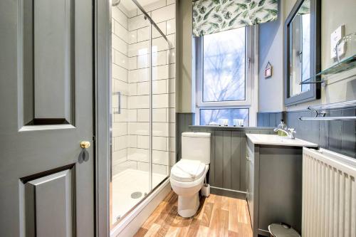 a bathroom with a toilet and a shower and a sink at GuestReady - Stylish 2BR in Heart of Tollcross in Edinburgh