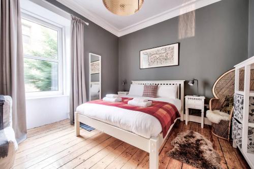 a bedroom with a large bed and a window at GuestReady - Stylish 2BR in Heart of Tollcross in Edinburgh