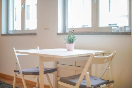 a table and two chairs with a potted plant on it at GuestReady - Spacious and Modern Studio in Belém! in Lisbon