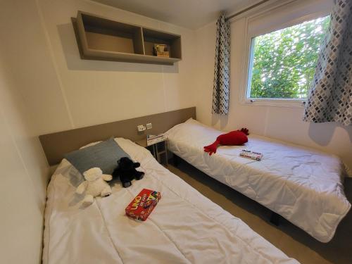 two beds with stuffed animals on them in a room at Fabuleux mobil-homme 4/6 personnes in Fréjus