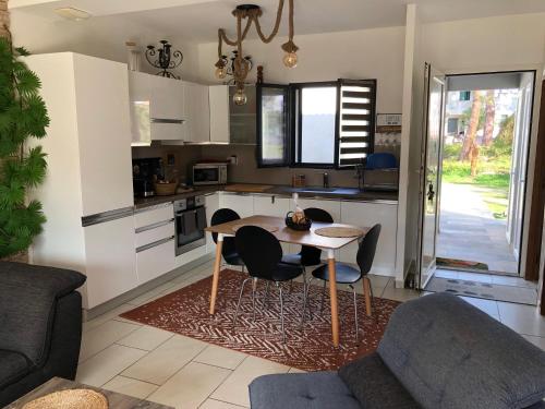 une cuisine avec une table et des chaises dans une pièce dans l'établissement maison de vacance en corse, à Borgo