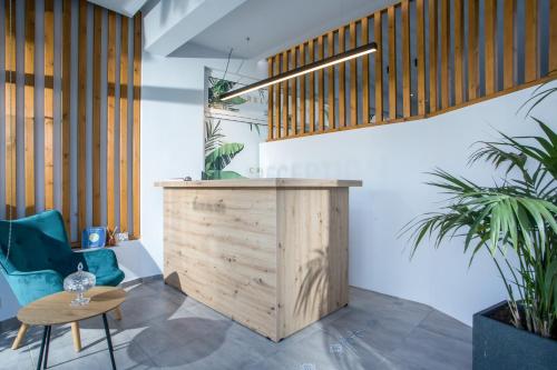 a lobby with a wooden counter and two plants at Casa Stavris in Faliraki