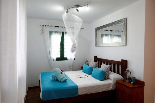 ヤイサにあるMi Pescaitoの青い枕が付いたベッドのある寝室