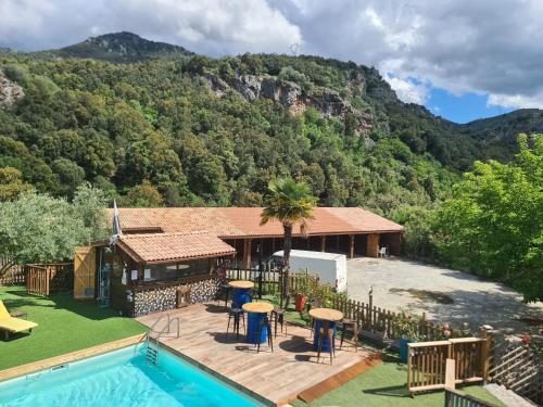 a house with a swimming pool next to a mountain at o fil de l'eau in Omessa