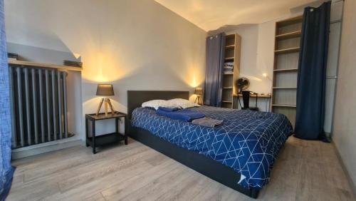 - une chambre avec un lit et une couette bleue dans l'établissement Le Grand Appart' Toulon, à Toulon