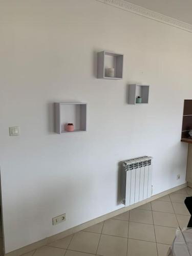 un mur blanc avec trois fenêtres dans une pièce dans l'établissement Les Cistes Appt type 3 avec terrasse vue sur mer, à Propriano