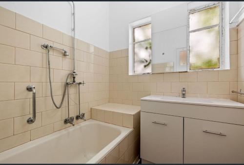 a bathroom with a tub and a sink and a shower at Ashburton big Room with shared bathroom 1 in Chadstone