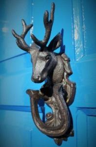 a bronze deer head hanging on a blue wall at Tirindrish House B&B in Spean Bridge
