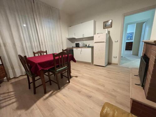 een keuken en eetkamer met een tafel en een koelkast bij Appartamento in centro, a 150 m dal mare in Pineto