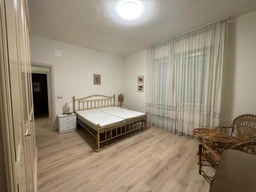 een slaapkamer met een bed en een houten vloer bij Appartamento in centro, a 150 m dal mare in Pineto