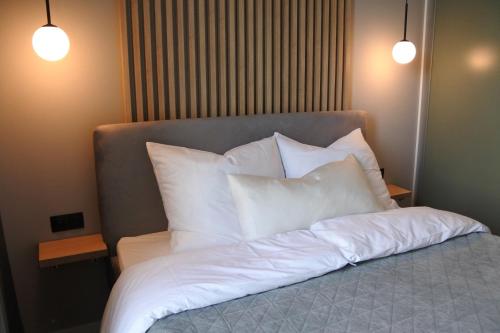 a bed with white pillows on top of it at Penthouse Apartment mit Meerblick und Dachterrasse in Gaski bei Mielno in Gąski