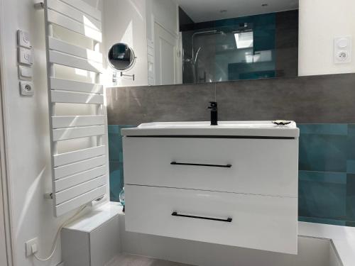 une salle de bain blanche avec un lavabo et un miroir dans l'établissement Maison Familiale- Bassin Arcachon - Au calme, à La Teste-de-Buch