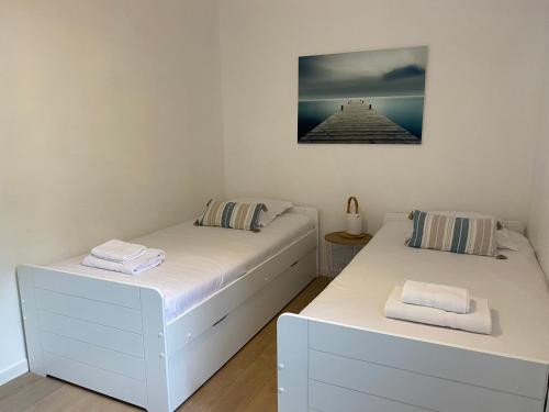 deux lits dans une chambre avec un tableau au mur dans l'établissement Maison Familiale- Bassin Arcachon - Au calme, à La Teste-de-Buch