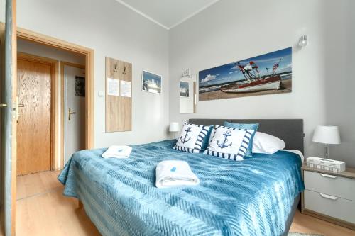 a bedroom with a bed with towels on it at Stawa Villa & Apart in Świnoujście