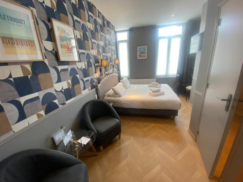 a small room with a bed and a chair at Hôtel De Wimereux in Wimereux