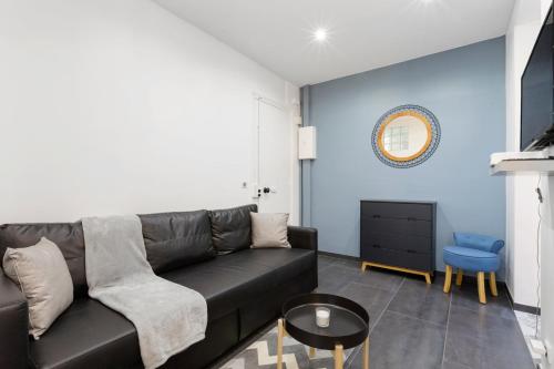 un salon avec un canapé noir et une table dans l'établissement GuestReady - Nice apartment for 6 in Paris, à Paris
