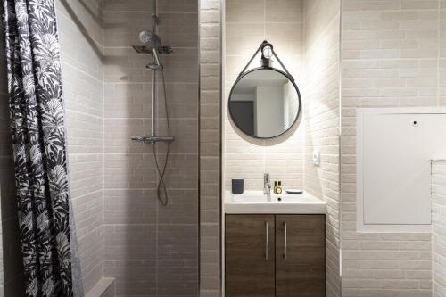 une salle de bain avec une douche avec un lavabo et un miroir dans l'établissement The Cute Sans-Souci Studio, à Lyon
