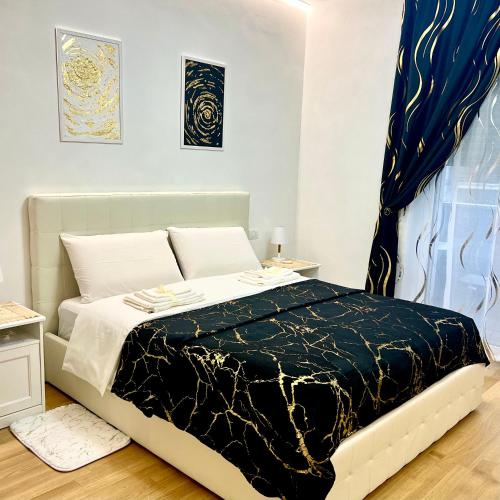 Schlafzimmer mit einem Bett mit einer schwarzen und weißen Bettdecke in der Unterkunft Angels apartment in Bari